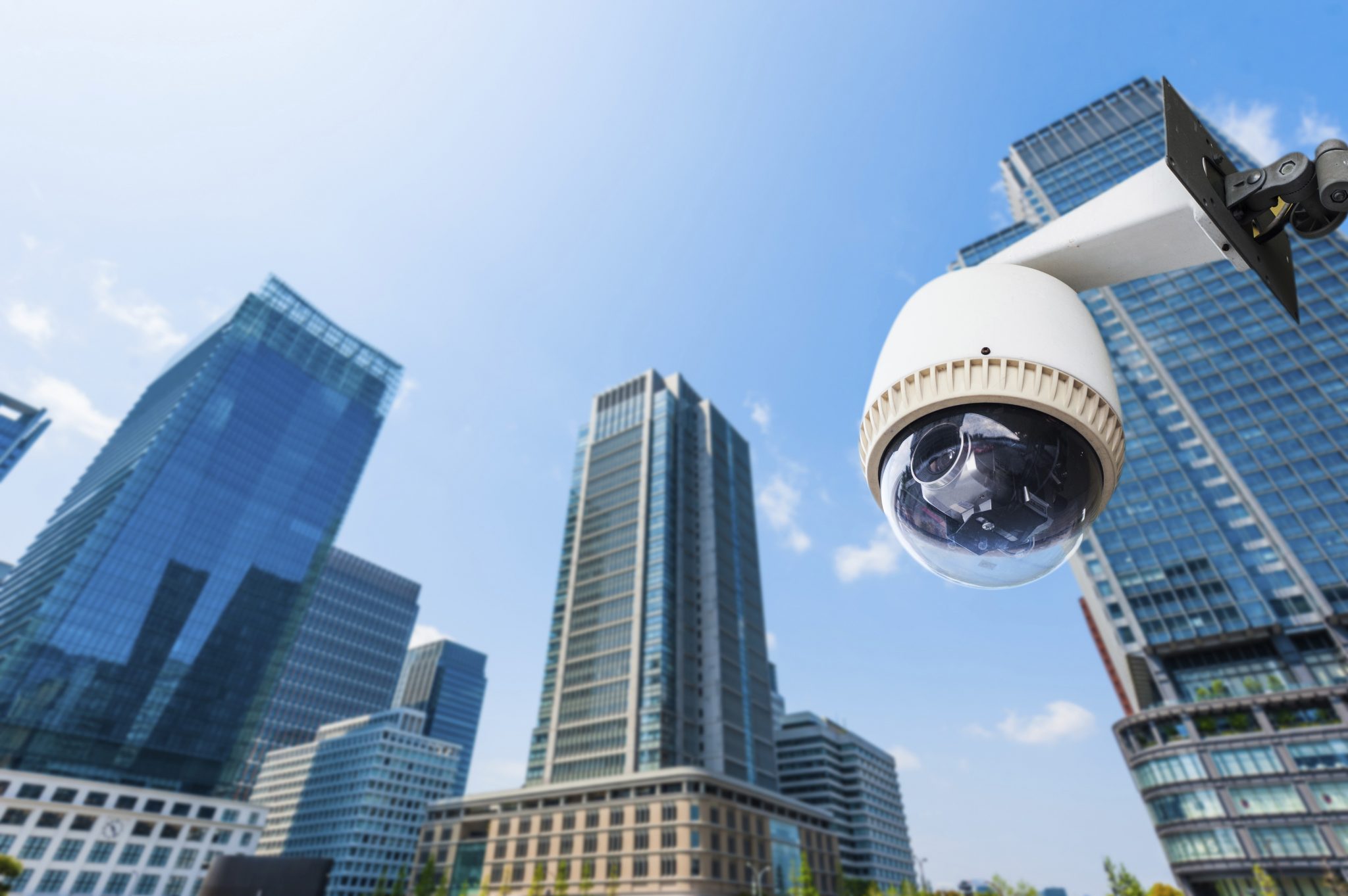 contact us - security solutions - security technology - CCTV Camera or surveillance operating with building in background